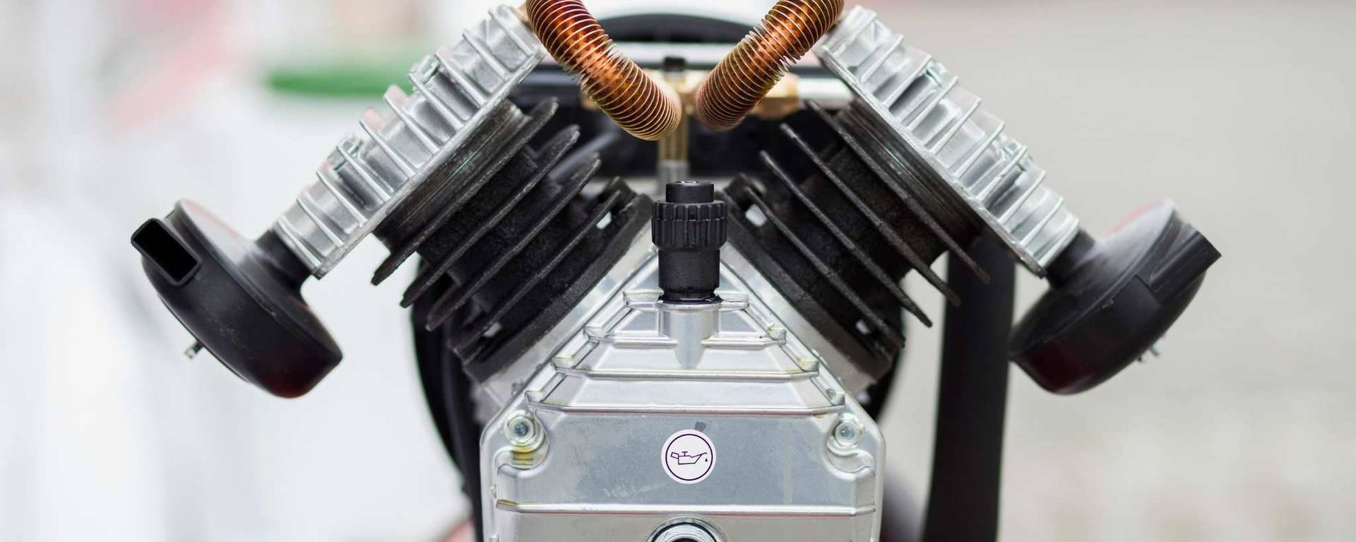 Close-up view of a V-shaped air compressor pump often used in car detailing