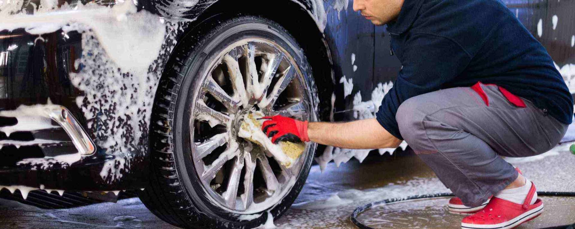 man cleaning the wheels of a car