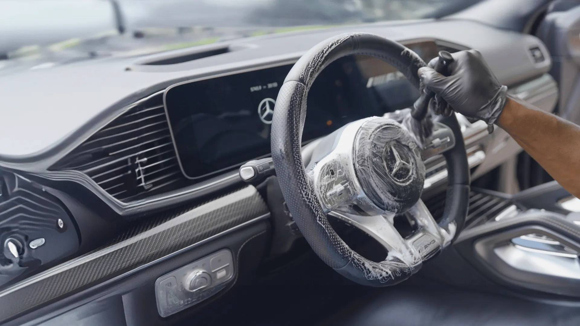 Detailer cleaning the steering wheel of a car