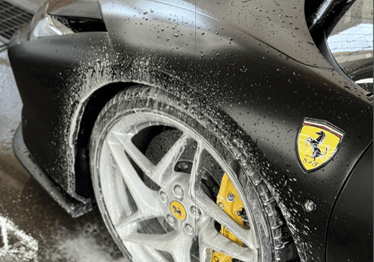 exotic car getting detailed, hand wash and foam on tire ting